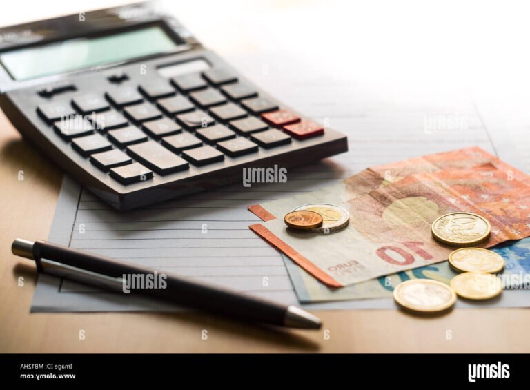 calculatrice et pieces de monnaie sur table
