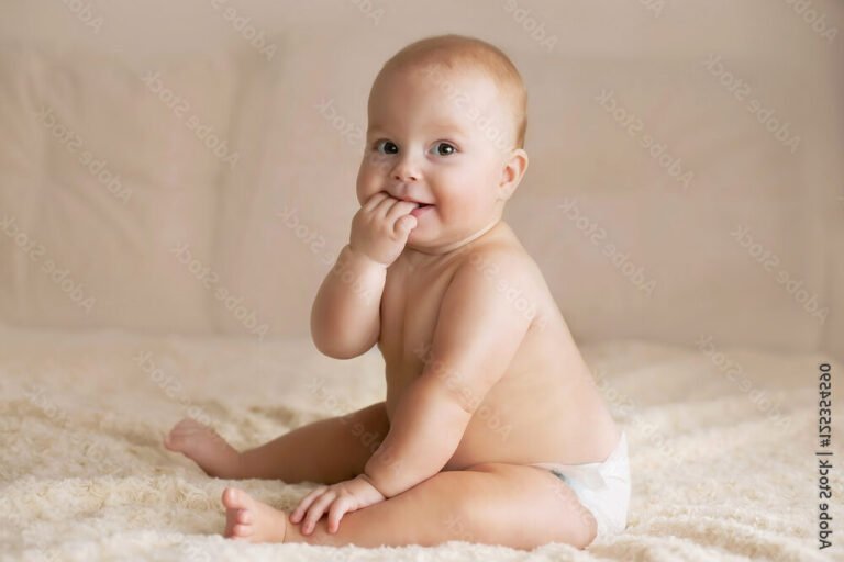 Que signifie l'expression "Qui y a-t-il dans ta couche" 44 un bebe souriant dans sa couche