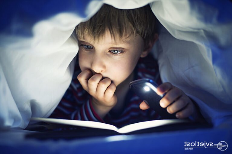 un enfant lisant un livre dans lobscurite