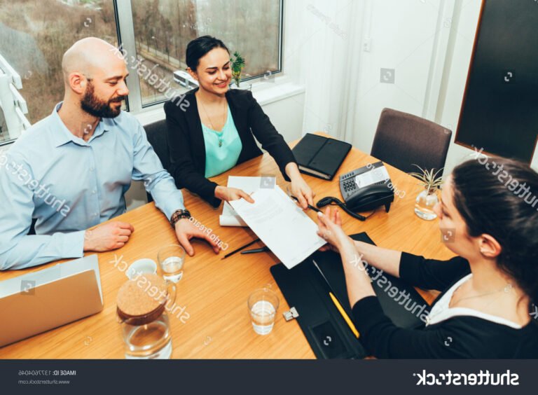 un groupe de personnes signant des documents