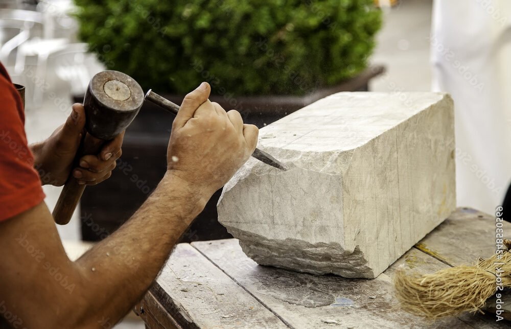 un homme sculptant de la pierre