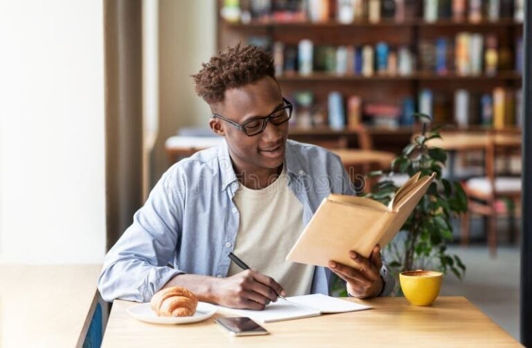 une personne lisant un livre dans un cafe